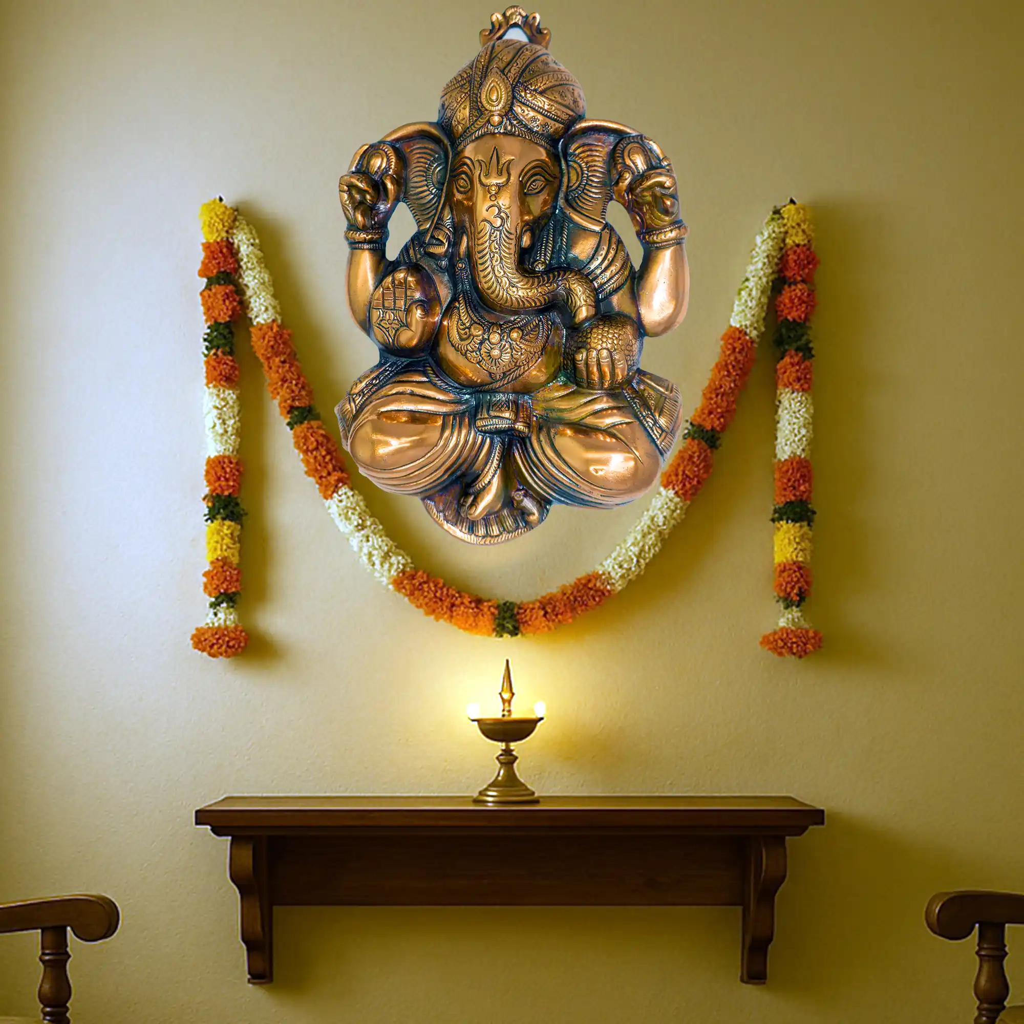 Ganesha aluminium metal wall decor in pooja room with garland and diya